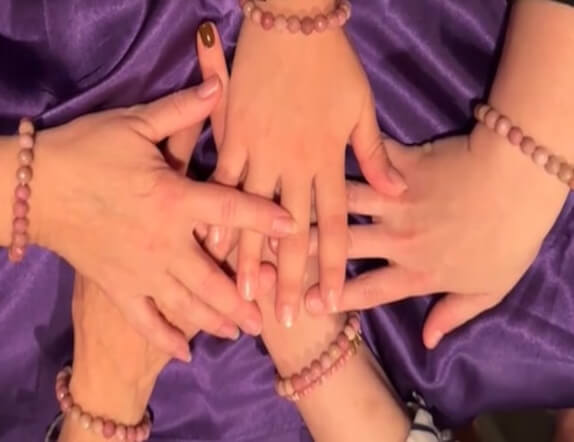 overhead photo of 5 women's hands in a circle